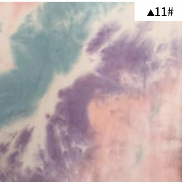 Tissu French Terry en coton tie-dye au mètre de Longan Craft France, imprimé en dégradé pastel mint, violet et pêche avec effet nuageux doux. Parfait pour vêtements confortables. Petite étiquette "▲11#" en haut à droite.