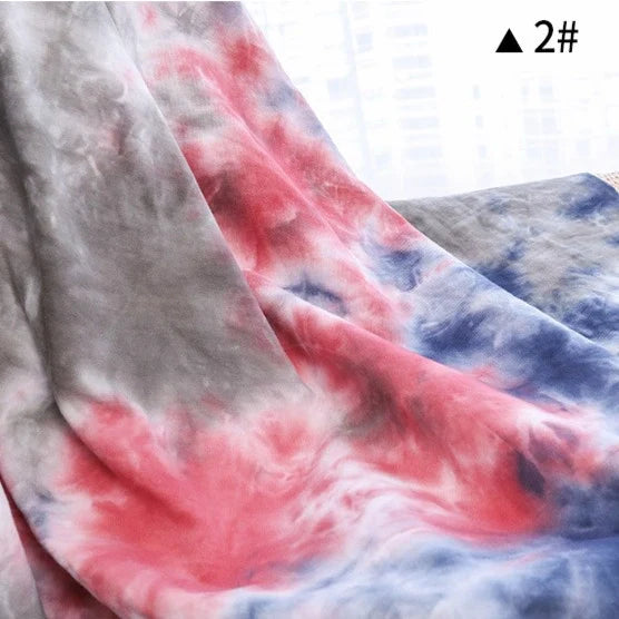 Gros plan sur le Tissu French Terry en coton tie-dye au mètre de Longan Craft France, motif dégradé rouge, bleu et gris, doux et confortable pour vêtements, avec l'étiquette "▲ 2#" visible dans le coin.