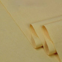 Gros plan sur le Tissu sergé coton et lyocell au mètre de Longan Craft France en jaune clair, montrant sa surface douce et légèrement texturée et son bord plié - un textile idéal et respirant pour les chemises.