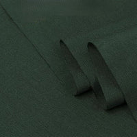 Gros plan sur le tissu sergé coton et lyocell au mètre de Longan Craft France, un mélange de coton et de lyocell vert foncé avec un sergé diagonal subtil, respirant et confortable - parfait pour les chemises - présenté soigneusement plié sur une surface plane.