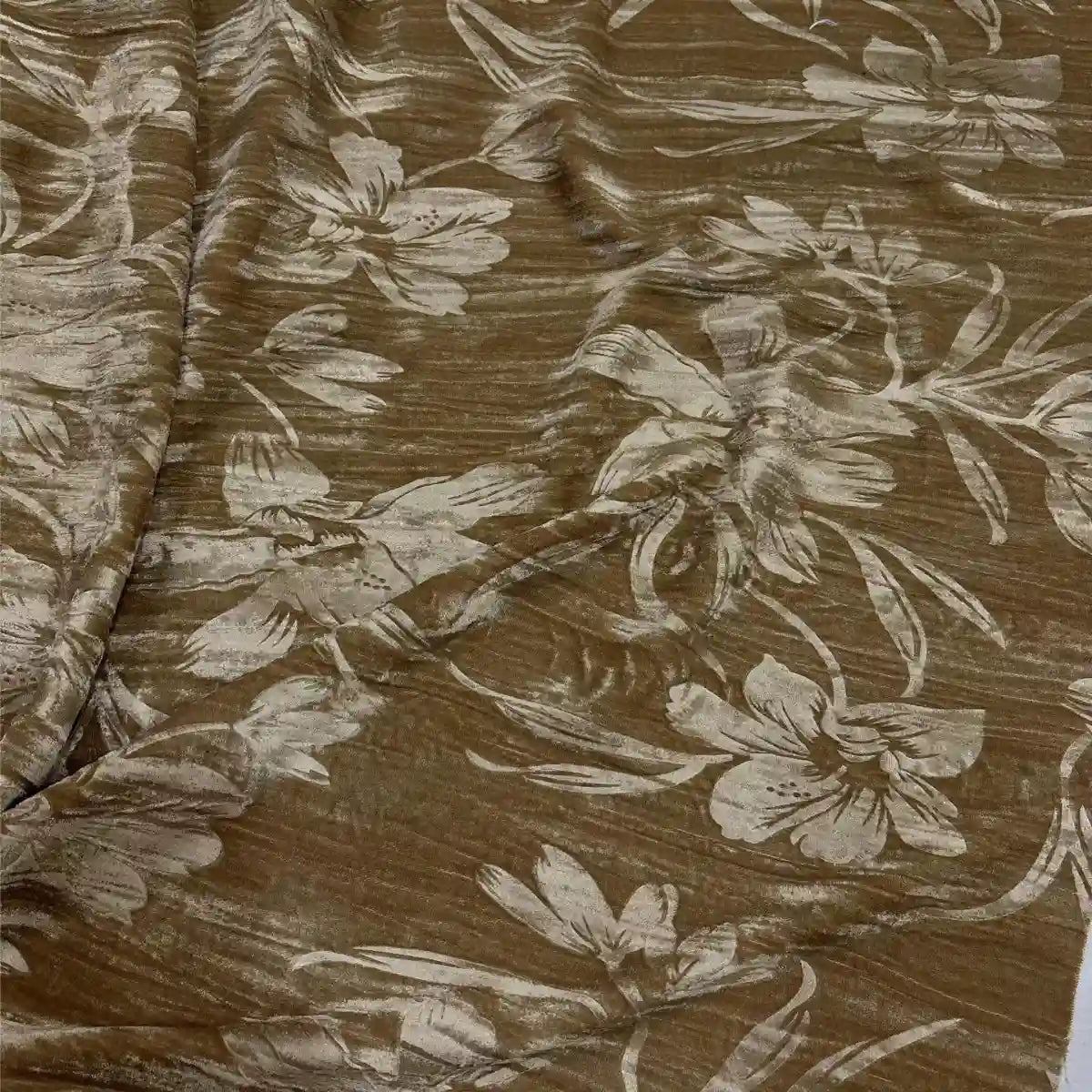Un gros plan du tissu velours damassé au mètre de Longan Craft France montre son design jacquard classique, avec de grands motifs floraux brillants dans des tons clairs sur un tissu brun subtilement texturé, idéal pour la confection de vêtements élégants.