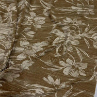 Un gros plan du tissu velours damassé au mètre de Longan Craft France montre son design jacquard classique, avec de grands motifs floraux brillants dans des tons clairs sur un tissu brun subtilement texturé, idéal pour la confection de vêtements élégants.