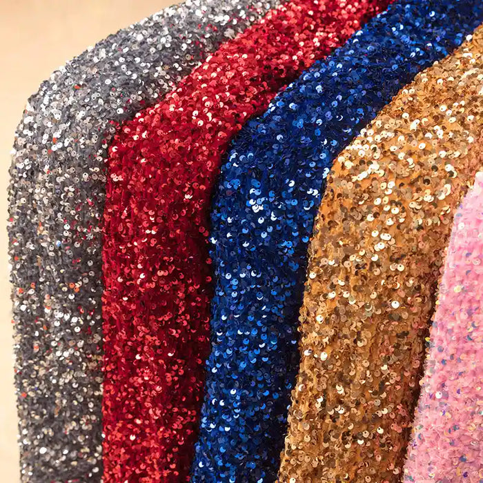 Gros plan sur le Tissu en velours extensible à paillettes de Longan Craft France, présenté en argent, rouge, bleu, or et rose. Le tissu extensible à paillettes reflète la lumière pour un effet scintillant, idéal pour la scène et les tenues de mode.