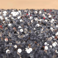 Gros plan sur des paillettes argentées très denses sur le tissu en velours extensible à paillettes de Longan Craft France, un tissu de velours extensible avec des broderies de paillettes en relief, idéal pour les vêtements de scène et de mode étincelants.