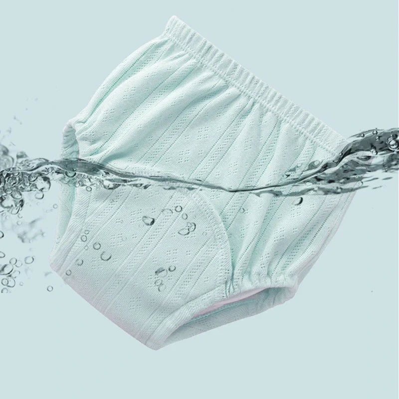 Un tissu pointelle côtelé polyester vert clair de Longan Craft France, vendu au mètre pour les vêtements d'intérieur DIY, est partiellement immergé dans l'eau sur un fond bleu clair uni, avec des éclaboussures et des bulles d'air visibles autour du tissu.