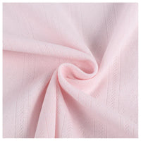 Gros plan sur le tissu pointelle côtelé vertical au mètre de Longan Craft France, un tissu polyester rose pâle aux rayures subtiles et aux motifs délicats, légèrement froncé pour montrer son drapé - idéal pour les vêtements d'intérieur DIY.