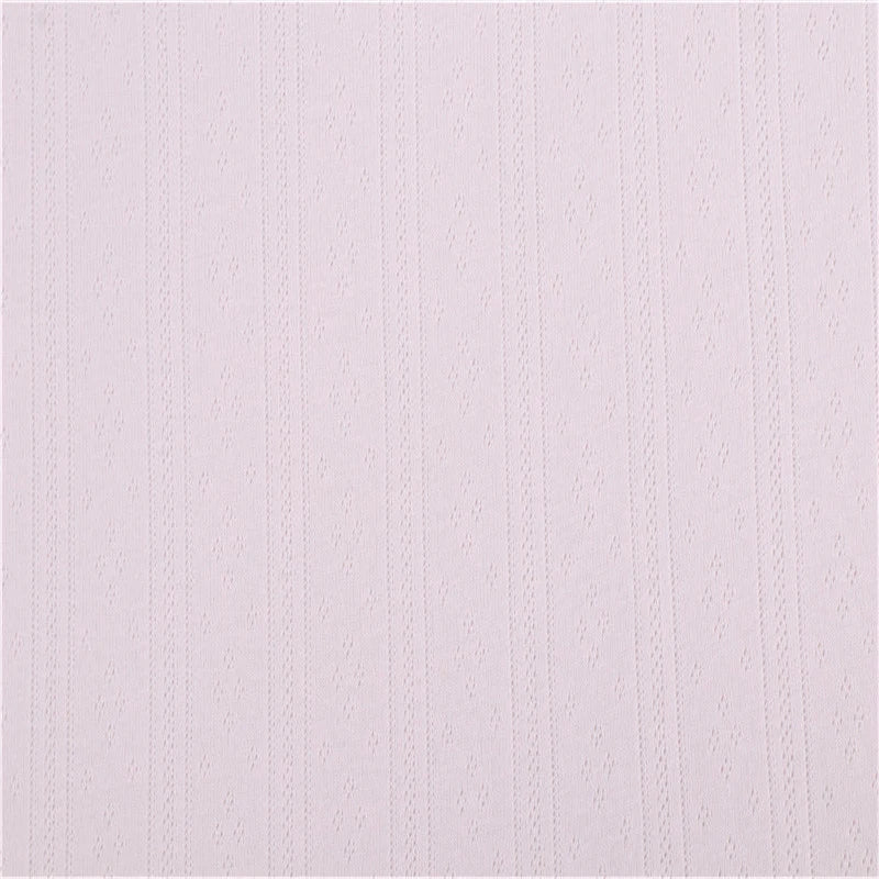Le Tissu pointelle côtelé vertical au mètre de Longan Craft France, en polyester uni rose pâle avec rayures subtiles et motifs losanges répétés, offre une texture douce idéale pour vos vêtements d'intérieur DIY.