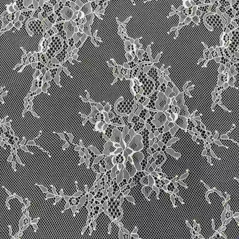 Gros plan sur la Dentelle Chantilly blanche au mètre de Longan Craft France, un tissu français de dentelle florale aux bords festonnés, présentant des motifs de fleurs et de feuilles complexes sur une maille fine - idéal pour les robes de mariée DIY.