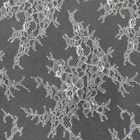 Gros plan sur la Dentelle Chantilly blanche au mètre de Longan Craft France, un tissu français de dentelle florale aux bords festonnés, présentant des motifs de fleurs et de feuilles complexes sur une maille fine - idéal pour les robes de mariée DIY.