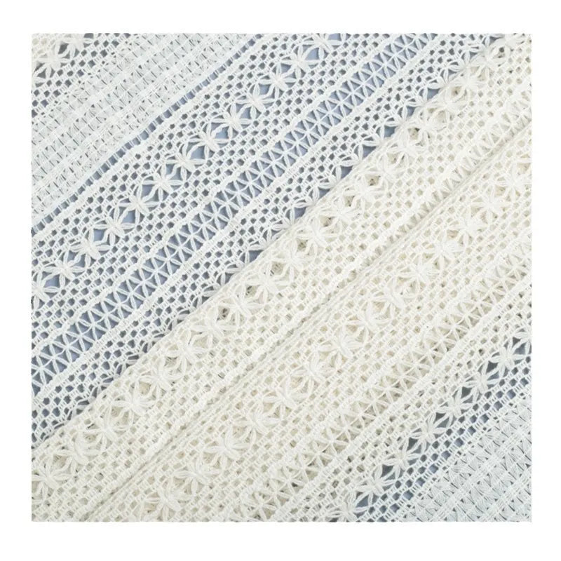 Gros plan sur plusieurs bandes de Tissu dentelle en coton blanc au mètre Dentelle jacquard ajourée de Longan Craft France, montrant des motifs complexes, disposés en diagonale sur un fond clair - idéal pour la confection de peignoirs.