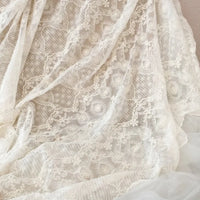 Gros plan sur le Tissu dentelle brodée florale blanche au mètre de Longan Craft France, mettant en valeur les motifs complexes de la dentelle florale - parfait comme tissu de dentelle de mariage vintage pour les projets de couture.