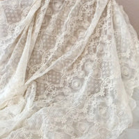 Le Tissu dentelle brodée florale blanche au mètre de Longan Craft France, une dentelle de mariage vintage, présente une délicate broderie florale et est élégamment présenté sur une surface blanche.