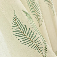 Gros plan sur le tissu de rideau en tulle blanc à motifs feuilles de Longan Craft France, qui présente de délicats motifs botaniques disposés en diagonale sur le tissu transparent et élégant, vendu au mètre.