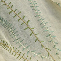Gros plan sur le tissu de rideau en tulle blanc à motifs feuilles de Longan Craft France, un tissu d'ameublement transparent aux motifs feuillus disponible au mètre.