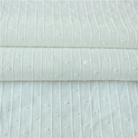 Gros plan sur le Tissu jacquard à rayures blanches et plumetis au mètre de Longan Craft France, qui présente des lignes verticales piquées et des points blancs régulièrement espacés sur un tissu suisse transparent.