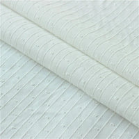 Gros plan sur le tissu jacquard à rayures blanches et plumetis au mètre de Longan Craft France, un tissu suisse transparent à rayures blanches et texture pointillée, présenté plié proprement.