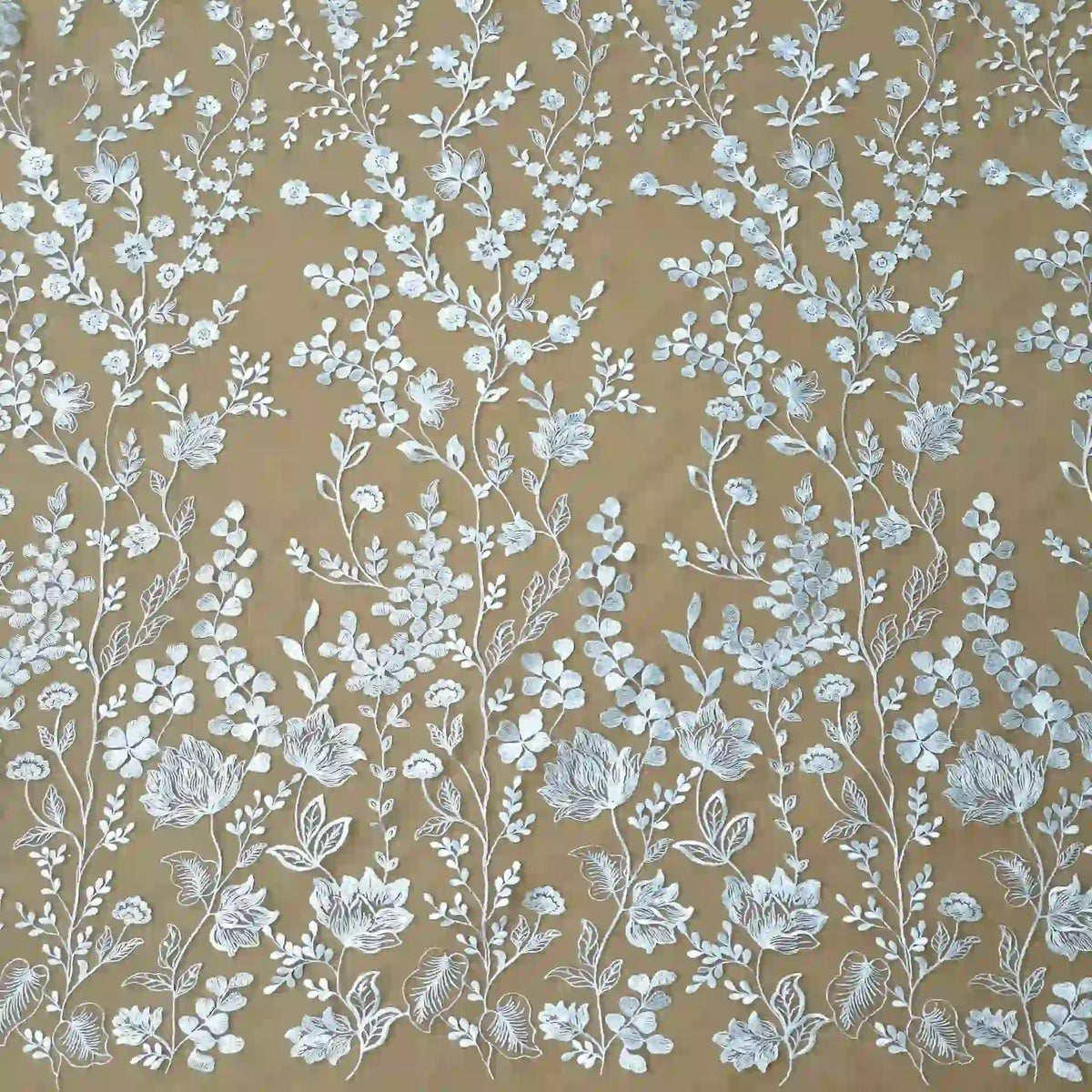 Le tulle brodé floral blanc au mètre de Longan Craft France présente d'élégantes broderies florales blanches dans un motif vertical symétrique sur un tulle marron clair - parfait pour la confection de vêtements de cérémonie élégants.