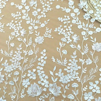 Le Tulle brodé floral blanc au mètre pour couture de robe élégante de Longan Craft France présente une broderie de dentelle florale blanche avec des fleurs et des feuilles sur un tulle transparent beige clair - idéal pour créer des robes de cérémonie élégantes.