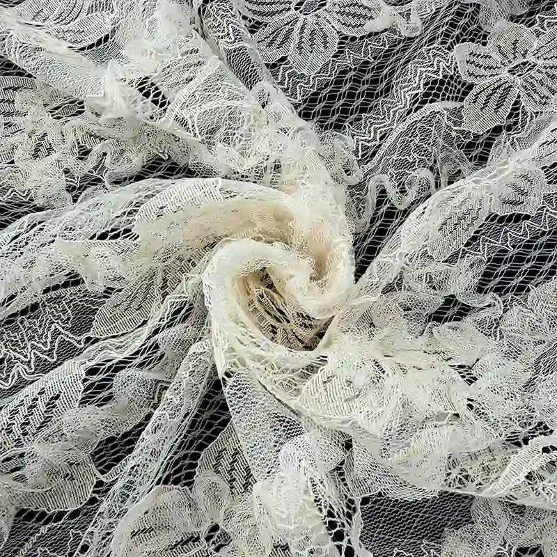 Gros plan sur le tissu en dentelle 3D au mètre de Longan Craft France, un tissu en dentelle brodée de couleur blanc cassé avec des motifs floraux complexes et des mailles, parfait pour la mode printemps/été ou les jupes.