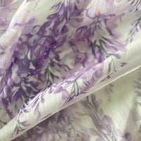 Gros plan sur le tissu mousseline imprimé fleurs de glycine violettes de Longan Craft France, un tissu floral léger et transparent au mètre, parfait pour la couture et les projets doux et élégants.