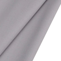 Gros plan sur le tissu gabardine de laine peignée au mètre de Longan Craft France, un tissu sergé en laine-polyester gris clair, légèrement brillant, plié en diagonale, idéal pour les costumes sur mesure.