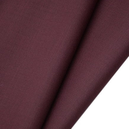 Un gros plan sur le tissu gabardine de laine peignée au mètre de Longan Craft France révèle sa texture sergée, lisse et finement tissée. Ce mélange résistant de laine et de polyester est idéal pour les costumes sur mesure.