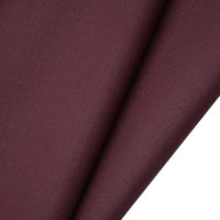 Un gros plan sur le tissu gabardine de laine peignée au mètre de Longan Craft France révèle sa texture sergée, lisse et finement tissée. Ce mélange résistant de laine et de polyester est idéal pour les costumes sur mesure.