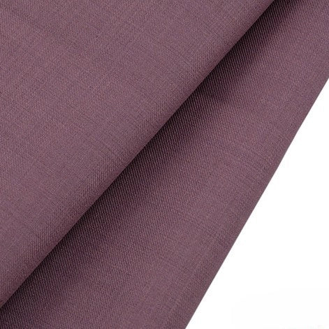 Gros plan sur un pliage de Tissu gabardine de laine mauve peignée au mètre de Longan Craft France, un tissu infroissable en laine et polyester à la texture subtilement lisse, parfait pour les costumes sur mesure. Le fond est blanc.