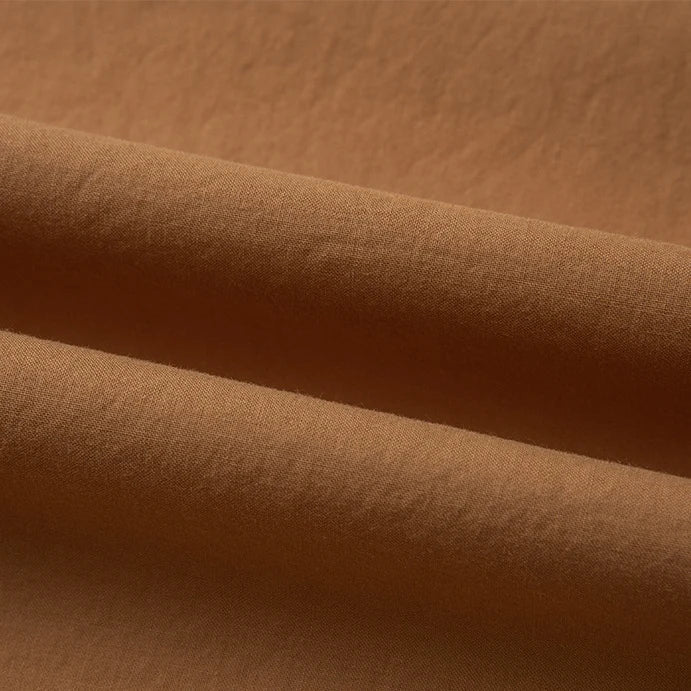 Gros plan sur le Tissu linon de coton tissé au mètre de Longan Craft France en marron clair, présentant une surface lisse et légèrement texturée - parfait comme doublure coton haute douceur pour les projets nécessitant du coton linon multicolore au mètre.