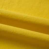 Gros plan sur le Tissu linon de coton tissé au mètre en jaune de Longan Craft France, un tissu de doublure en coton multicolore et ultra-doux montrant ses plis et ombres naturels.