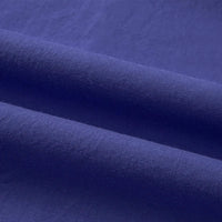 Gros plan sur le pliage du Tissu linon de coton tissé au mètre de Longan Craft France, mettant en valeur sa texture lisse, son aspect multicolore doux et les ombres légères le long des plis de coton à haute densité.