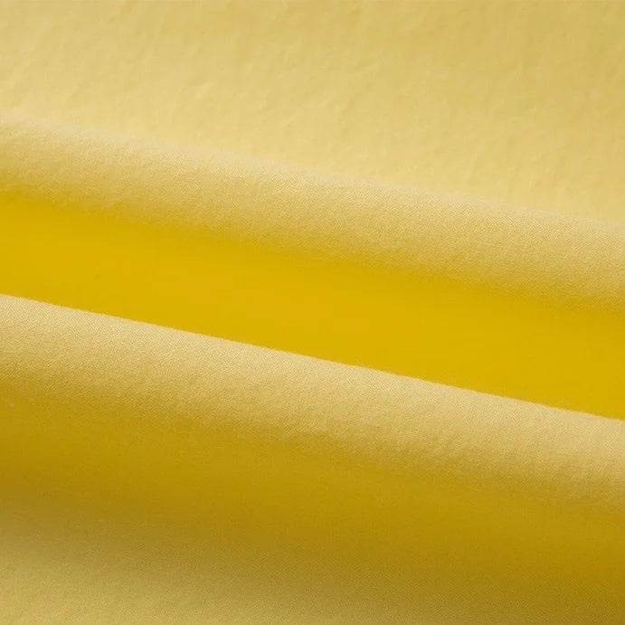Gros plan sur le Tissu linon de coton tissé au mètre de Longan Craft France, montrant des couches superposées de coton multicolore, doux et mat, convenant à une doublure de grand confort.