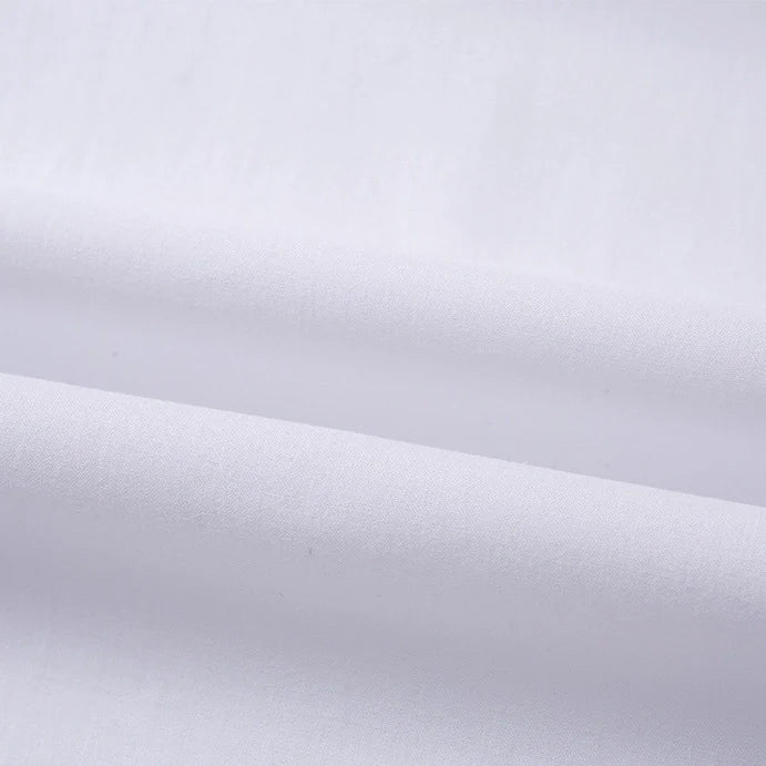 Gros plan sur le Tissu linon de coton tissé au mètre, lisse et blanc, de Longan Craft France, montrant des plis doux et des ombres légères qui mettent en valeur la texture fine et la qualité du tissage de ce Doublure coton haute douceur.