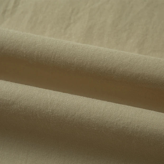 Un gros plan du Tissu linon de coton tissé au mètre de Longan Craft France montre sa surface lisse et légèrement texturée avec de légers plis horizontaux - parfait pour une doublure en coton multicolore d'une grande douceur.