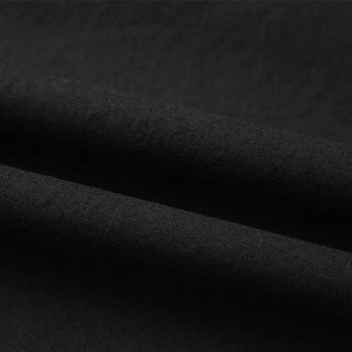 Un gros plan du Tissu linon de coton tissé au mètre de Longan Craft France révèle sa surface multicolore, doucement pliée et sa texture lisse, idéale comme doublure coton haute douceur.