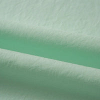 Gros plan sur le Tissu linon de coton tissé au mètre par Longan Craft France, un Coton linon multicolore vert clair avec une surface légèrement texturée et des plis horizontaux souples, idéal comme coton Doublure haute douceur.