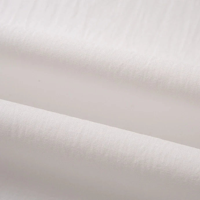 Gros plan sur le Tissu linon de coton tissé au mètre de Longan Craft France : cette doublure multicolore en coton haute douceur est légère, légèrement translucide et présente une texture douce avec une brillance subtile.