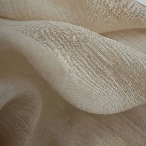 Gros plan sur le Tissu lyocell froissé au mètre de Longan Craft France - un tissu lyocell beige clair, respirant et durable, au tissage texturé et au drapé doux, parfait pour les hauts.