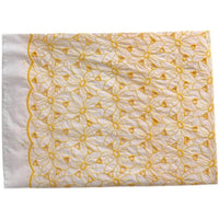 Tissu brodé ajouré œillet jaune au mètre de Longan Craft France : tissu coton 100 % brodé œillet, motif floral jaune entrelacé et bord festonné sur un côté.