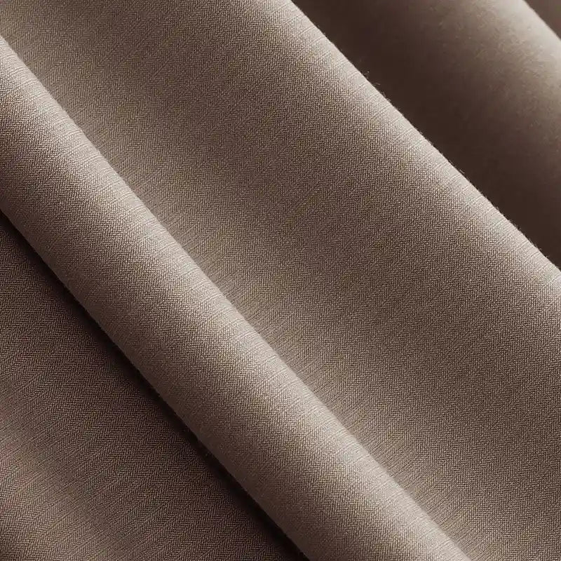 Gros plan sur le Jersey modal uni au mètre, lisse et brun, de Longan Craft France, montrant un subtil tissage en diagonale. Ce tissu coton-modal est doux, respirant et parfait pour les vêtements de nuit. L'ombre et la lumière mettent en valeur sa texture homogène.