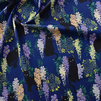Longan Craft France Tissu popeline coton imprimé floral chat : un tissu bleu foncé avec des motifs de chats parmi des fleurs violettes, jaunes et vertes, idéal pour DIY, patchwork, robes, chemises et décoration intérieure.