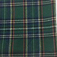 Un gros plan du "Tissu flanelle à carreaux de Noël" de Longon Craft France montre son motif écossais vert avec des lignes entrecroisées de couleur marine, rouge, blanche et jaune - idéal pour les peignoirs de fête, les chemises, les travaux manuels et les projets de couture.