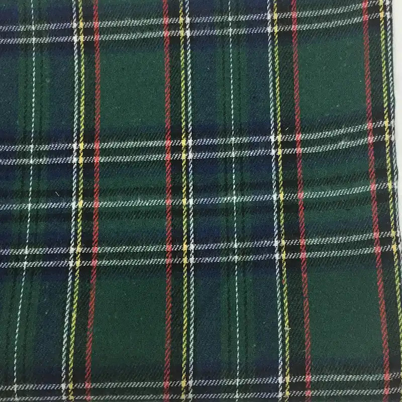 Un gros plan du "Tissu flanelle à carreaux de Noël" de Longon Craft France montre son motif écossais vert avec des lignes entrecroisées de couleur marine, rouge, blanche et jaune - idéal pour les peignoirs de fête, les chemises, les travaux manuels et les projets de couture.