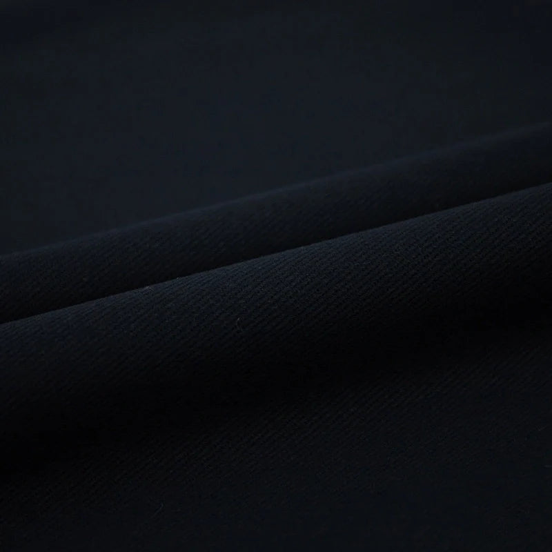 Gros plan sur le pliage du Tissu jean coloré 7,5 oz au mètre de Longan Craft France, un denim 100 % coton sergé multicolore de haute qualité dont la surface lisse et légèrement texturée met en valeur le tissage et l'épaisseur du tissu.