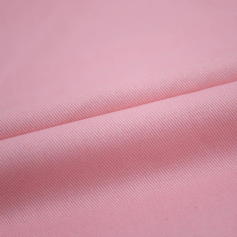 Gros plan sur le Tissu jean coloré 7,5 oz au mètre de Longan Craft France-100% coton denim sergé multicolore avec de fines nervures diagonales et des plis lisses, parfait pour les jeans colorés, les vêtements, ou la décoration.