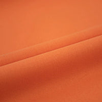 Gros plan sur le Tissu jean coloré 7,5 oz de Longan Craft France : denim multicolore 100% coton à la texture lisse et au tissage subtil, idéal pour les jeans, les vêtements et la décoration, présenté avec de légers plis.