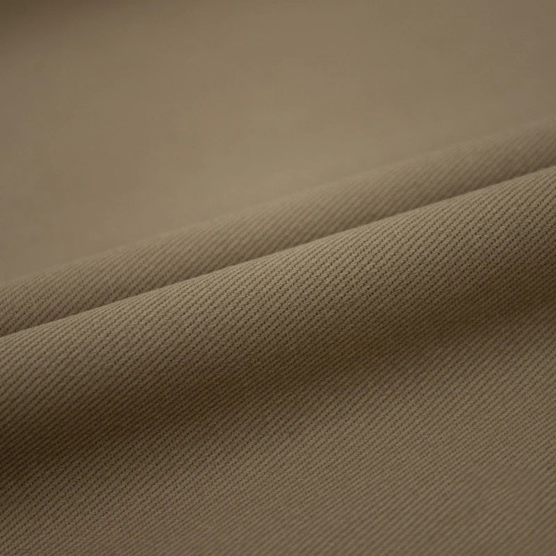 Un gros plan du Tissu jean coloré 7,5 oz au mètre de Longan Craft France révèle un tissage denim subtil en diagonale et des plis doux - idéal pour les jeans en coton colorés et la décoration.