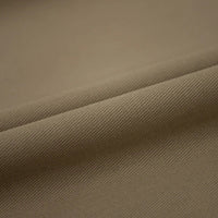 Un gros plan du Tissu jean coloré 7,5 oz au mètre de Longan Craft France révèle un tissage denim subtil en diagonale et des plis doux - idéal pour les jeans en coton colorés et la décoration.