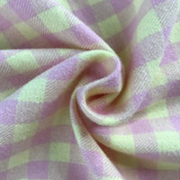 Gros plan sur la flanelle de coton à carreaux colorés de Longon Craft France, un tissu 100 % coton à carreaux jaune pastel et lavande, torsadé en spirale - parfait pour les manteaux, les chemises, la couture et l'ameublement.