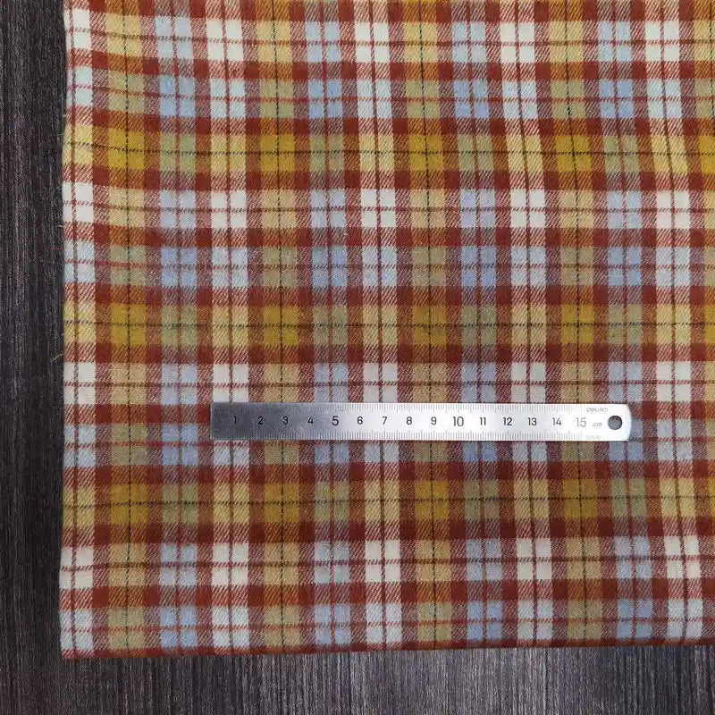 Le tissu en flanelle à carreaux colorés Longon Craft France, ultra-douillet pour l'automne, est présenté ici avec une règle métallique de 15 cm posée sur la matière polyester-coton confortable.